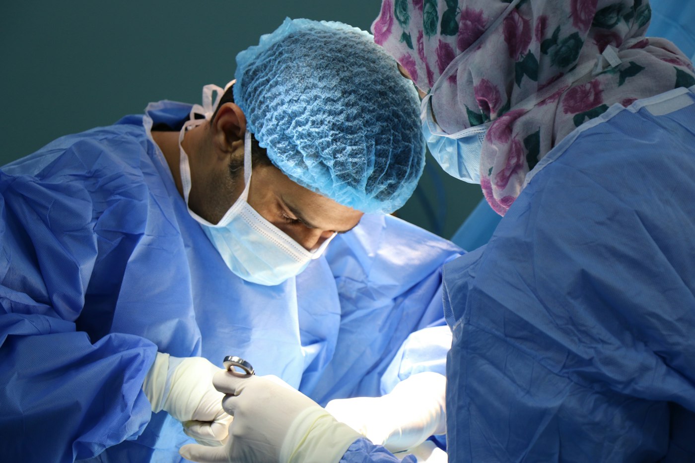 Surgeon in a blue surgical gown at work
